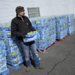 
              Volunteer Cory Brittain prepares to hand out free water in East Palestine, Ohio, as cleanup from the Feb. 3 Norfolk Southern train derailment continues, Friday, Feb. 24, 2023. (AP Photo/Matt Freed)
            