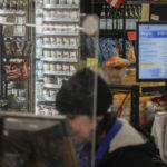 
              A cashier at a Gristedes supermarket works in view of a freezer holding Haagen-Dazs ice cream, Tuesday Jan. 31, 2023, in New York. "This is a high priority store for theft," said Matthew Calabrese, head of security at the store, who had the ice cream re-positioned within eyesight of cashiers to curtail its theft. (AP Photo/Bebeto Matthews)
            