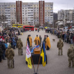 People attend the funeral of Ukrainian soldier Maksym in Obukhiv, near Kyiv, Ukraine, Thursday, Feb. 16, 2023. Maksym Katoshev, 22, a Ukrainian soldier of 72nd Mechanized Brigade, died on Feb. 10 during battles with the Russian troops defending the city of Vuhledar in the Donetsk region. (AP Photo/Emilio Morenatti)