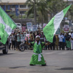 
              A demonstrator holds two Nigerian flags as he and others accusing the election commission of irregularities and disenfranchising voters make a protest in downtown Abuja, Nigeria, Tuesday, Feb. 28, 2023. Tensions rose in Nigeria Tuesday as the main opposition parties demanded a revote for the country's presidential election, where the latest results show an early lead for the ruling party. (AP Photo/Ben Curtis)
            