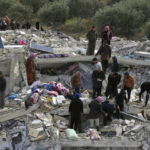
              Civil defense workers and residents search through the rubble of collapsed buildings in the town of Harem near the Turkish border, Idlib province, Syria, Monday, Feb. 6, 2023. A powerful earthquake has caused significant damage in southeast Turkey and Syria and many casualties are feared. Damage was reported across several Turkish provinces, and rescue teams were being sent from around the country. (AP Photo/Ghaith Alsayed)
            