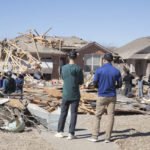 
              Neighbors look at damage to homes along Frost Lane on Monday, Feb. 27, 2023 in Norman, Okla. The damage came after rare severe storms and tornadoes moved through Oklahoma overnight. (AP Photo/Alonzo Adams)
            