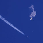 
              In this photo provided by Chad Fish, the remnants of a large balloon drift above the Atlantic Ocean, just off the coast of South Carolina, with a fighter jet and its contrail seen below it, Saturday, Feb. 4, 2023. The downing of the suspected Chinese spy balloon by a missile from an F-22 fighter jet created a spectacle over one of the state's tourism hubs and drew crowds reacting with a mixture of bewildered gazing, distress and cheering. (Chad Fish via AP)
            