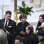 
              From left, Brian Fraser's father, Sean, mother, Mary 'Mia' and sister, Micaela, wait for Brian's casket to proceed into the church as family members friends and supporters gather during the funeral mass for Fraser at St Paul on the Lake Catholic Church, in Grosse Pointe Farms, Mich., Saturday, Feb.  18, 2023. Fraser was identified as one of three students slain during a mass shooting on Michigan State University's campus, Monday evening. (Todd McInturf/Detroit News via AP, Pool)
            