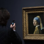 
              A journalist takes images of Girl with a Pearl Earring during a press preview of the Vermeer exhibit at Amsterdam's Rijksmuseum, Monday, Feb. 6, 2023, which unveils its blockbuster exhibition of 28 paintings by 17th-century Dutch master Johannes Vermeer drawn from galleries around the world. (AP Photo/Peter Dejong)
            