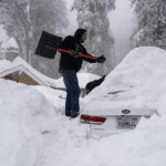 
              Kenny Rybak, 31, shovels snow around his car in Running Springs, Calif., Tuesday, Feb. 28, 2023. Beleaguered Californians got hit again Tuesday as a new winter storm moved into the already drenched and snow-plastered state, with blizzard warnings blanketing the Sierra Nevada and forecasters warning residents that any travel was dangerous. (AP Photo/Jae C. Hong)
            