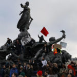
              Protesters stand on top of Place de la Nation statue at the end of a demonstration against plans to push back France's retirement age, in Paris, Saturday, Feb. 11, 2023. France is bracing itself for a fourth round of nationwide protests against President Emmanuel Macron's plans to reform pensions but key transports unions have not called for strikes allowing trains and the Paris metro to run this time. (AP Photo/Lewis Joly)
            
