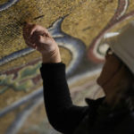 
              Restorer Chiara Zizola checks the consistency of the mosaics that adorn the dome of one of the oldest churches in Florence, St. John's Baptistery, in Florence, central Italy, during its restoration works, Tuesday Feb. 7, 2023. The restoration work will be done from an innovative scaffolding shaped like a giant mushroom that will stand for the next six years in the center of the church, and that will be open to visitors allowing them for the first and perhaps only time, to come come face to face with more than 1,000 square meters of precious mosaics covering the dome. (AP Photo/Andrew Medichini)
            