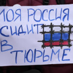 
              A woman holds a banner that reads in Russian: "My Russia sitting in prison!" during a rally in support of Russia's political prisoners in Belgrade, Serbia, Saturday, Jan. 21, 2023. A friendly, fellow-Slavic nation, Serbia has welcomed the fleeing Russians who need visas to travel to much richer Western European states. But in Serbia, they have not escaped the long reach of Putin's hardline regime influence. (AP Photo/Darko Vojinovic)
            
