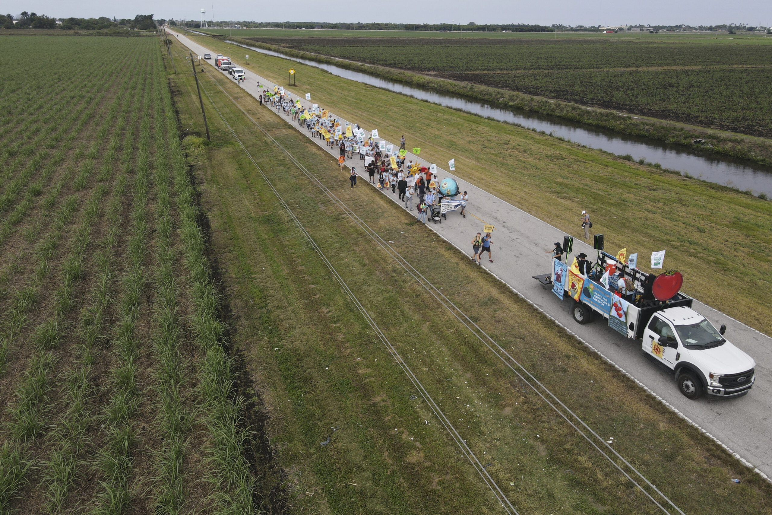 In this photo taken with a drone, farmworkers and allies march through agricultural land on the fir...