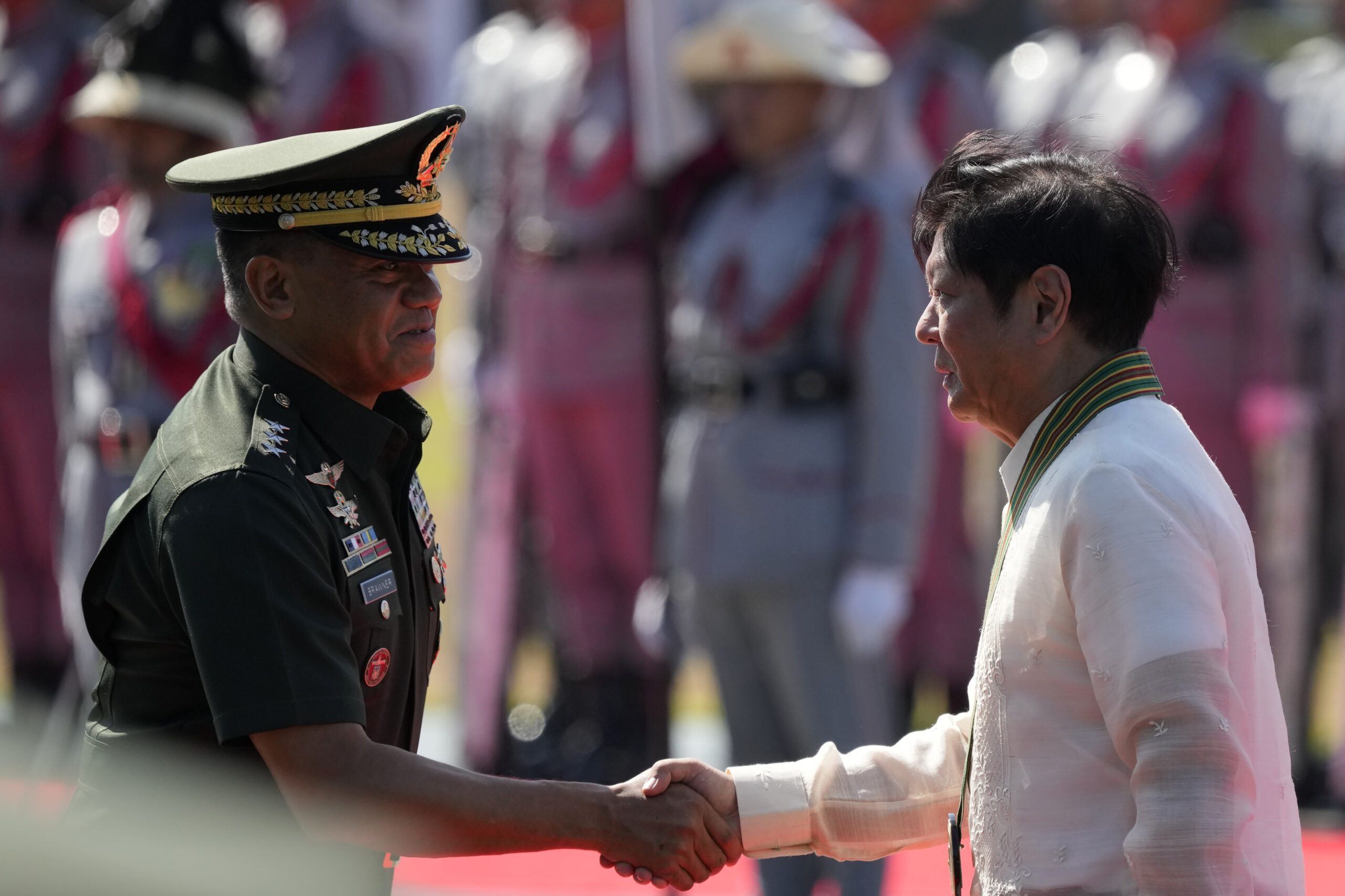 Philippine President Ferdinand Marcos Jr., right, shakes hands with Philippine Army Commanding Gene...