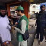 
              A police officer, right, stands guard as a government worker collects data from a man during census, in Peshawar, Pakistan, Wednesday, March 1, 2023. Pakistan on Wednesday launched its first-ever digital population and housing census to gather demographic data on every individual ahead of the parliamentary elections which are due later this year, officials said. (AP Photo/Muhammad Sajjad)
            