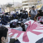 
              Protesters tear a banner with the Japanese rising-sun flag during a rally against the South Korean government's move to improve relations with Japan, in front of the Japanese Embassy in Seoul, South Korea, Wednesday, March 1, 2023. South Korea's president on Wednesday called Japan "a partner that shares the same universal values" and renewed hopes to repair ties frayed over Japan's colonial rule of the Korean Peninsula. (AP Photo/Ahn Young-joon)
            