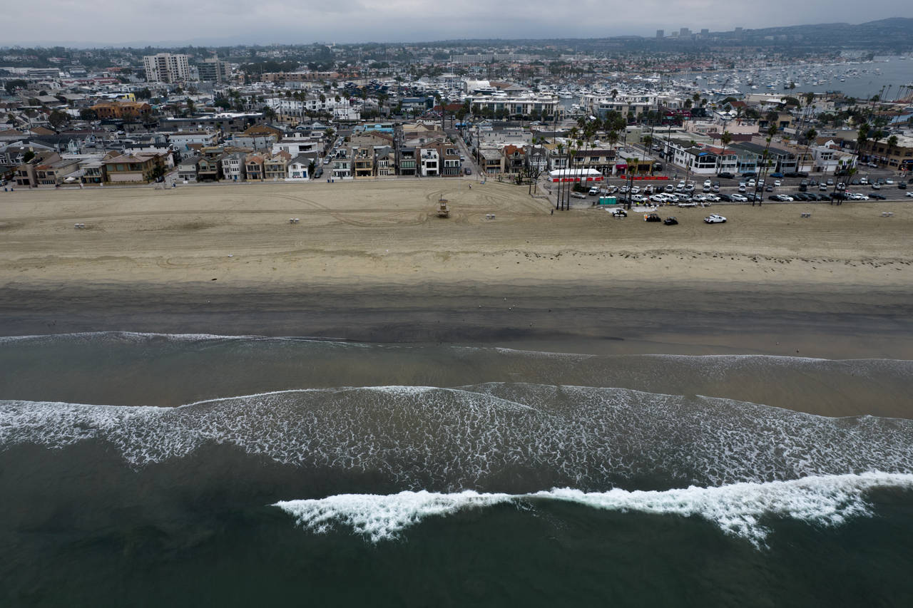 FILE - This aerial image taken with a drone, shows the closed beach after oil washed up in Newport ...