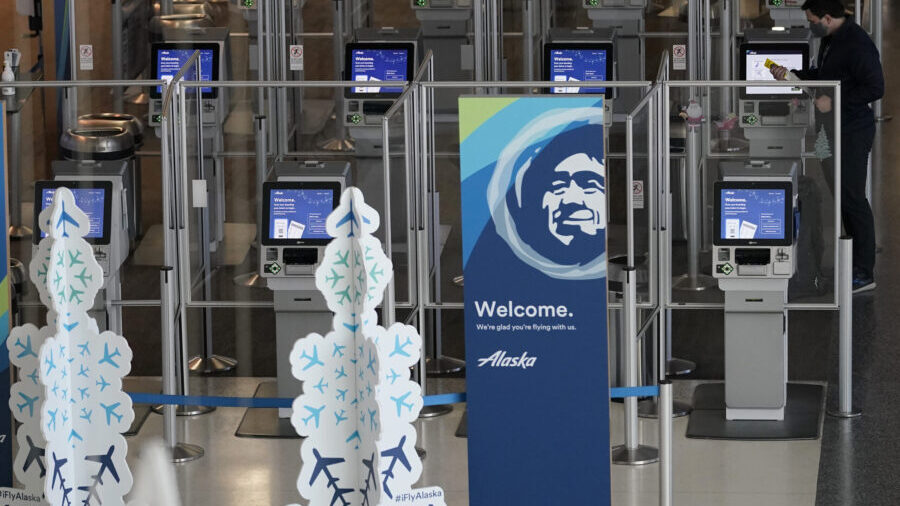 FILE - A traveller stands at an Alaska Airlines kiosk at San Francisco International Airport during...