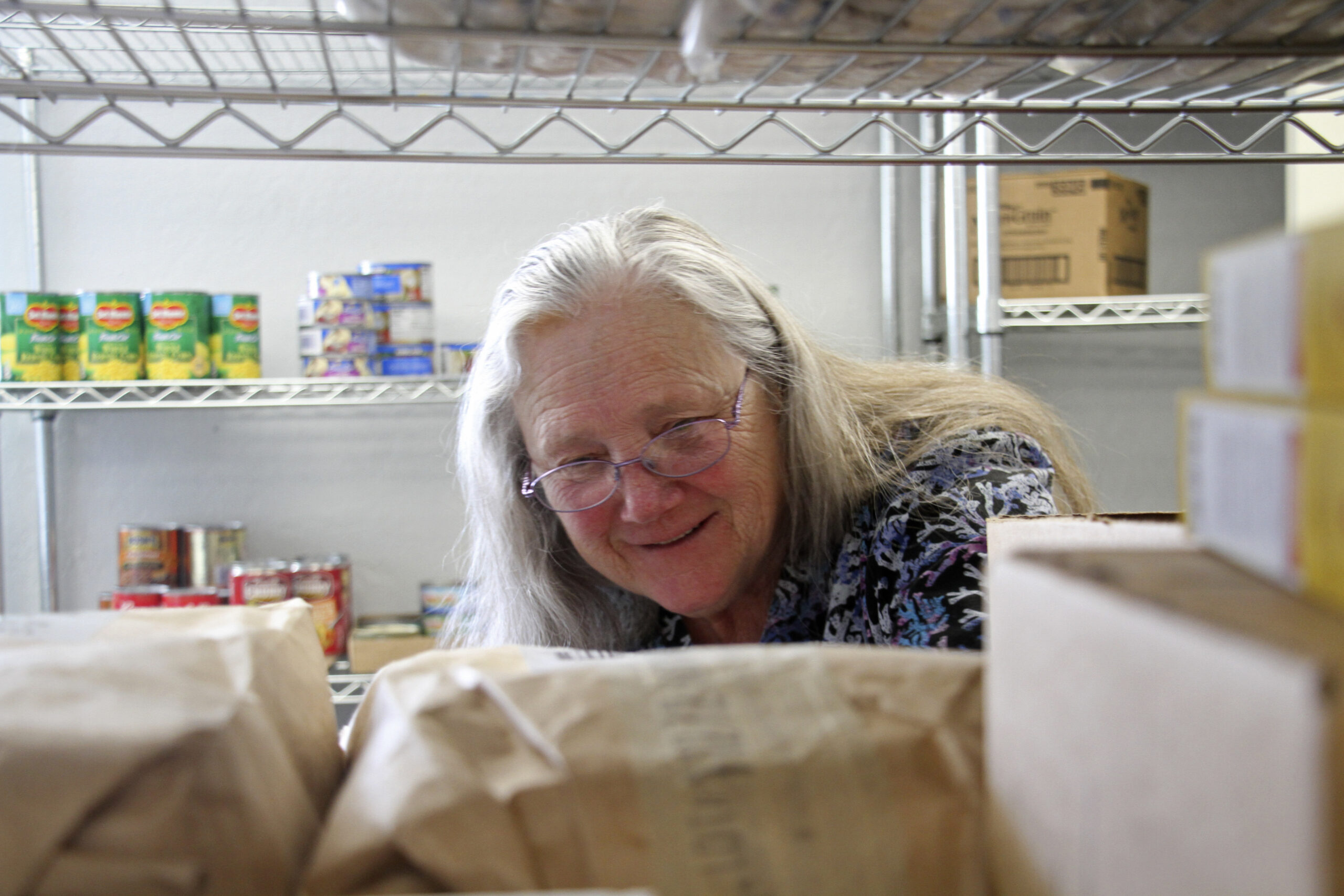 Rose Carney is shown organizing supplies at the food pantry at Harvest Christian Fellowship Church ...