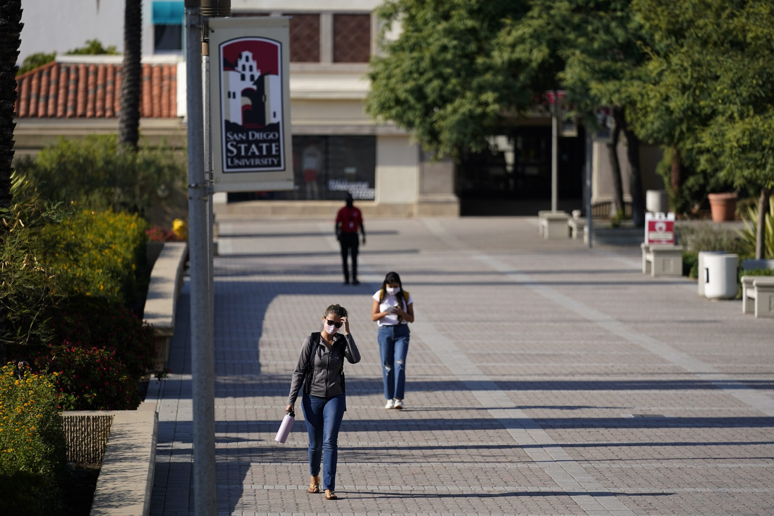 FILE - People walk on campus at San Diego State University, in San Diego on Sept. 2, 2020. Student ...