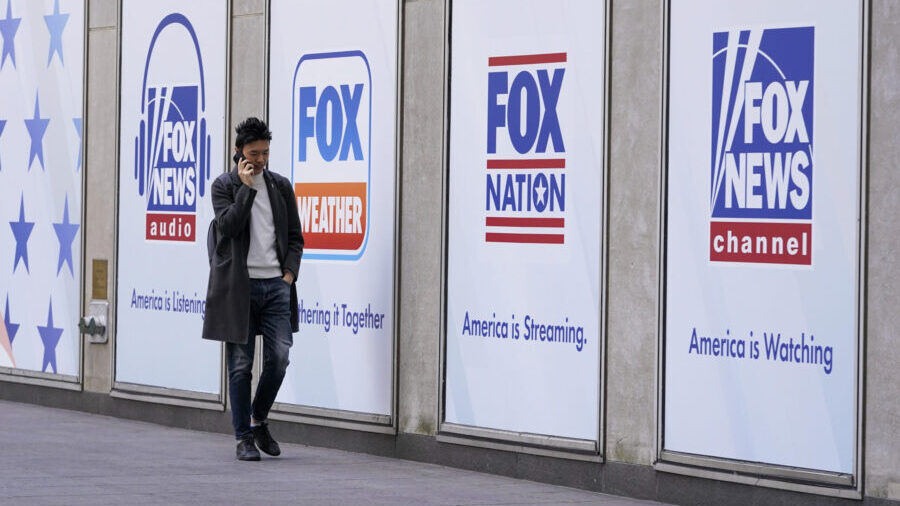 File - A man walks past the News Corp. and Fox News headquarters on Wednesday, April 19, 2023, in N...