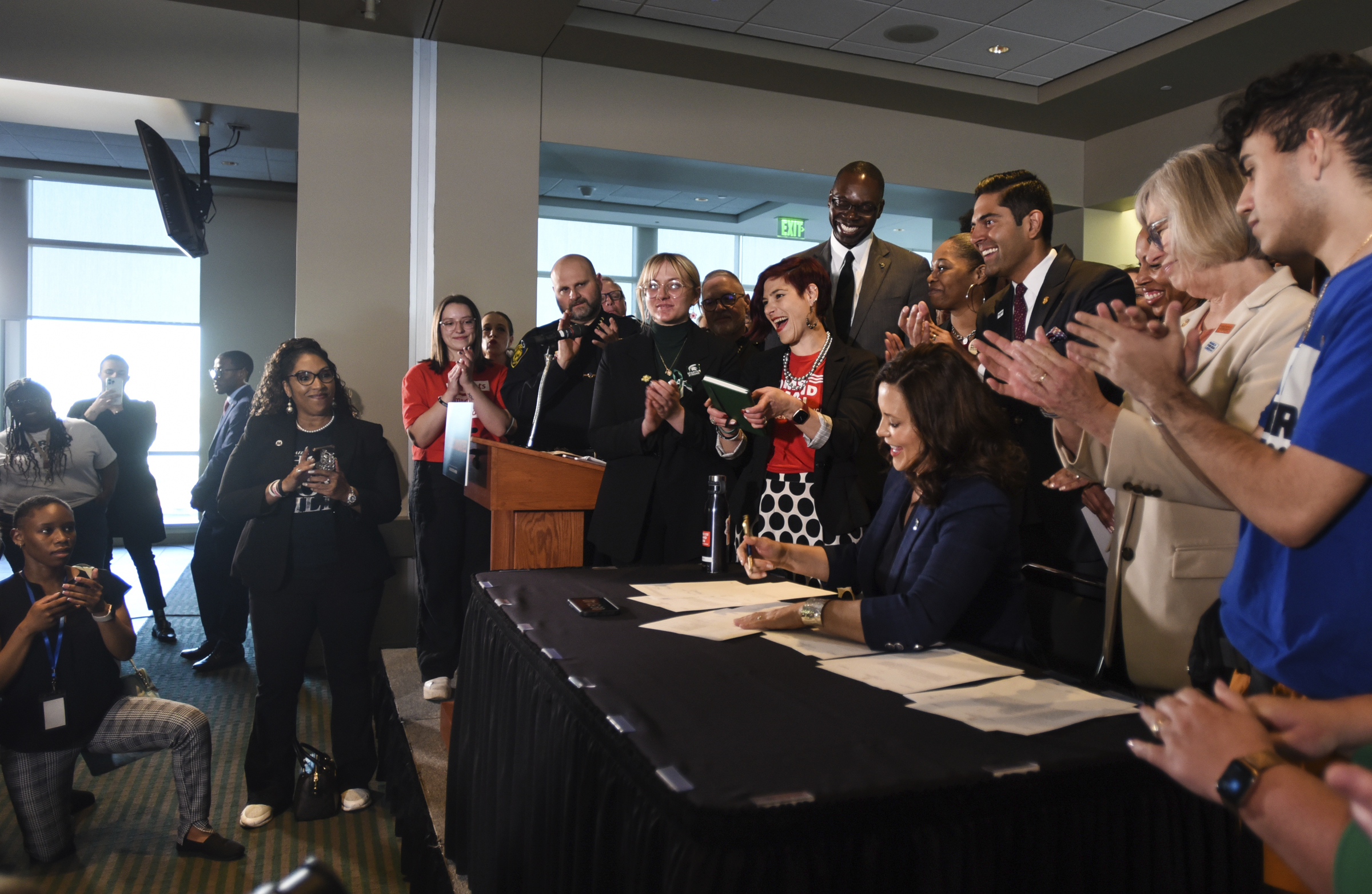 Michigan Gov. Gretchen Whitmer, seated at right, signs a package of gun bills Thursday, April 13, 2...