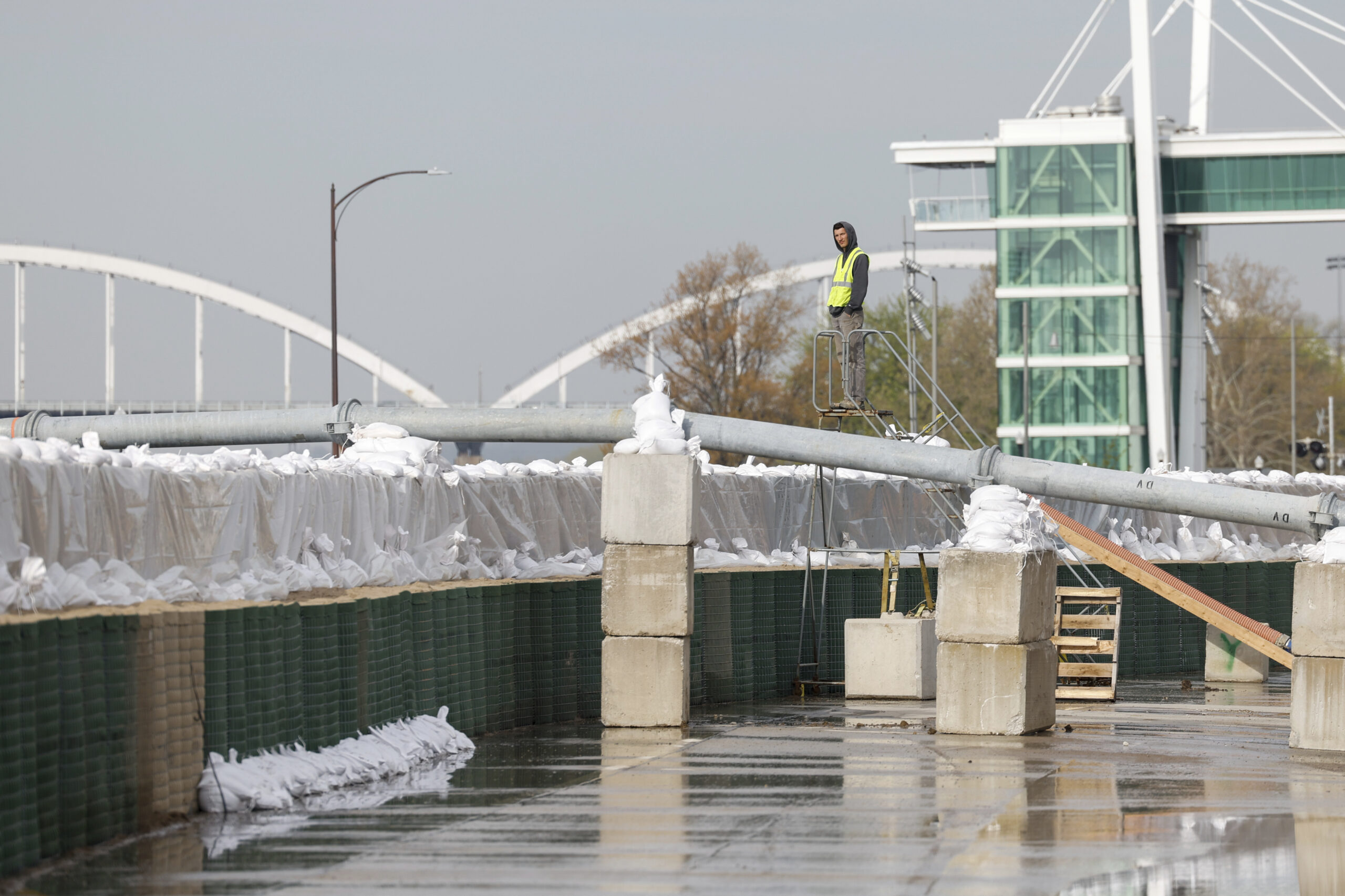 A city worker inspects the HESCO sand barriers along River Drive between Iowa and Perry Streets, Fr...