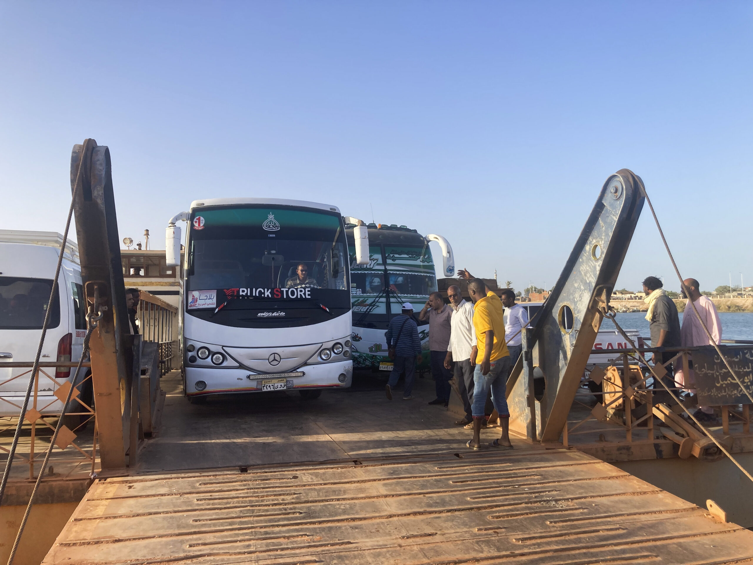 Buses carrying Sudanese, who fled the fighting in Sudan's capital, are leaving a ferry that transpo...