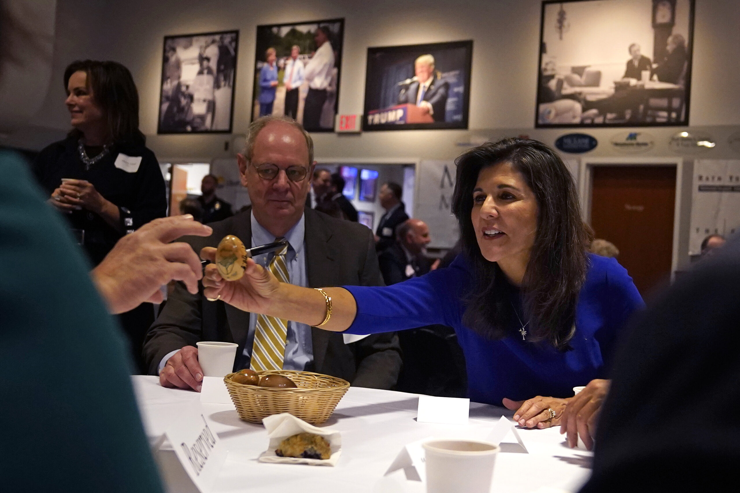 Republican presidential candidate Nikki Haley passes an autographed wooden egg to a guest during a ...
