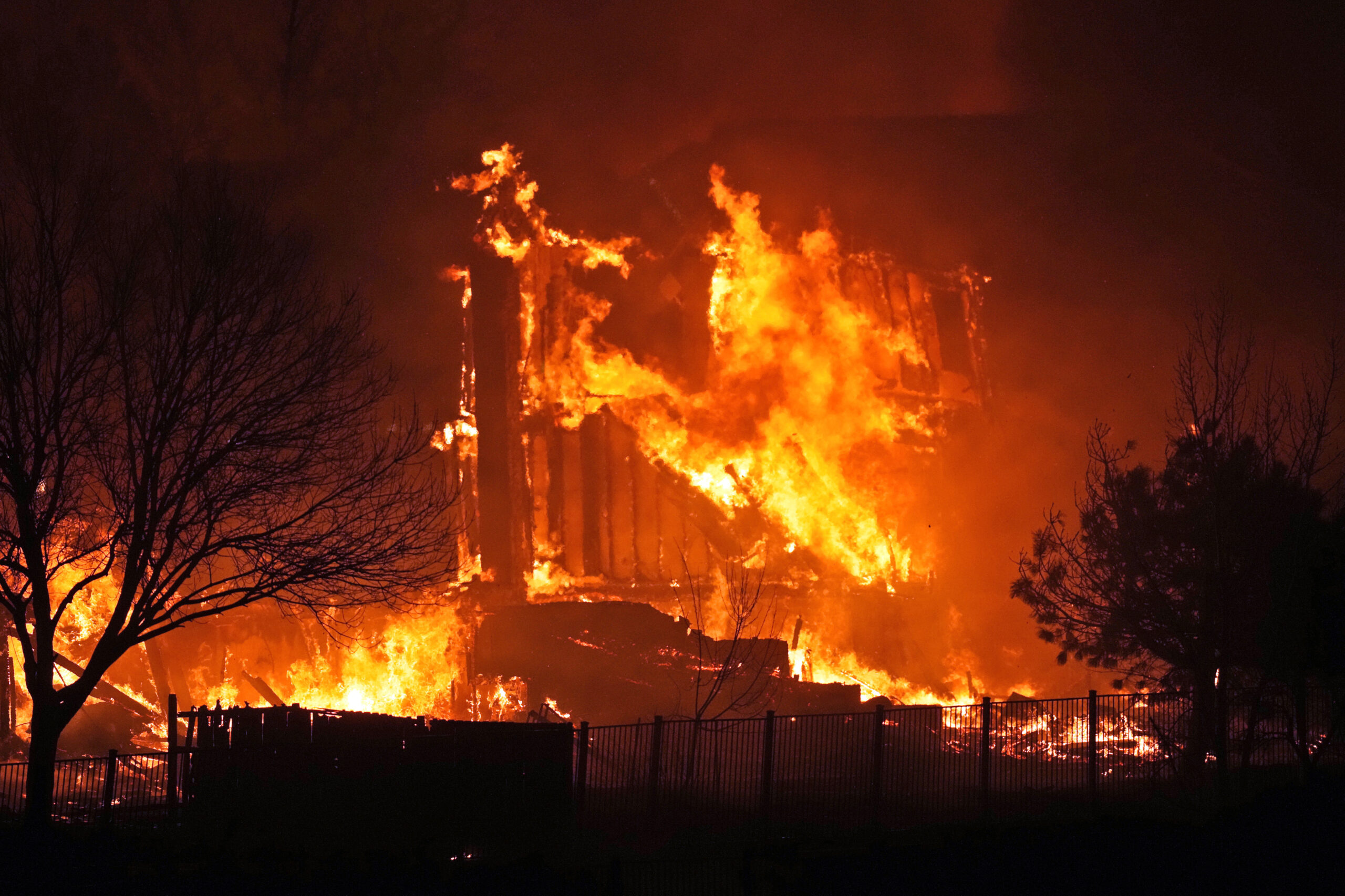 FILE - Homes burn as a wildfire rips through a development near Rock Creek Village, Dec. 30, 2021, ...
