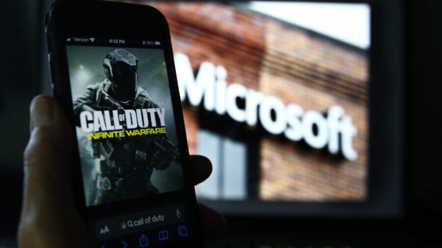 An image from Activision's Call of Duty is shown on a smartphone near a photograph of the Microsoft...