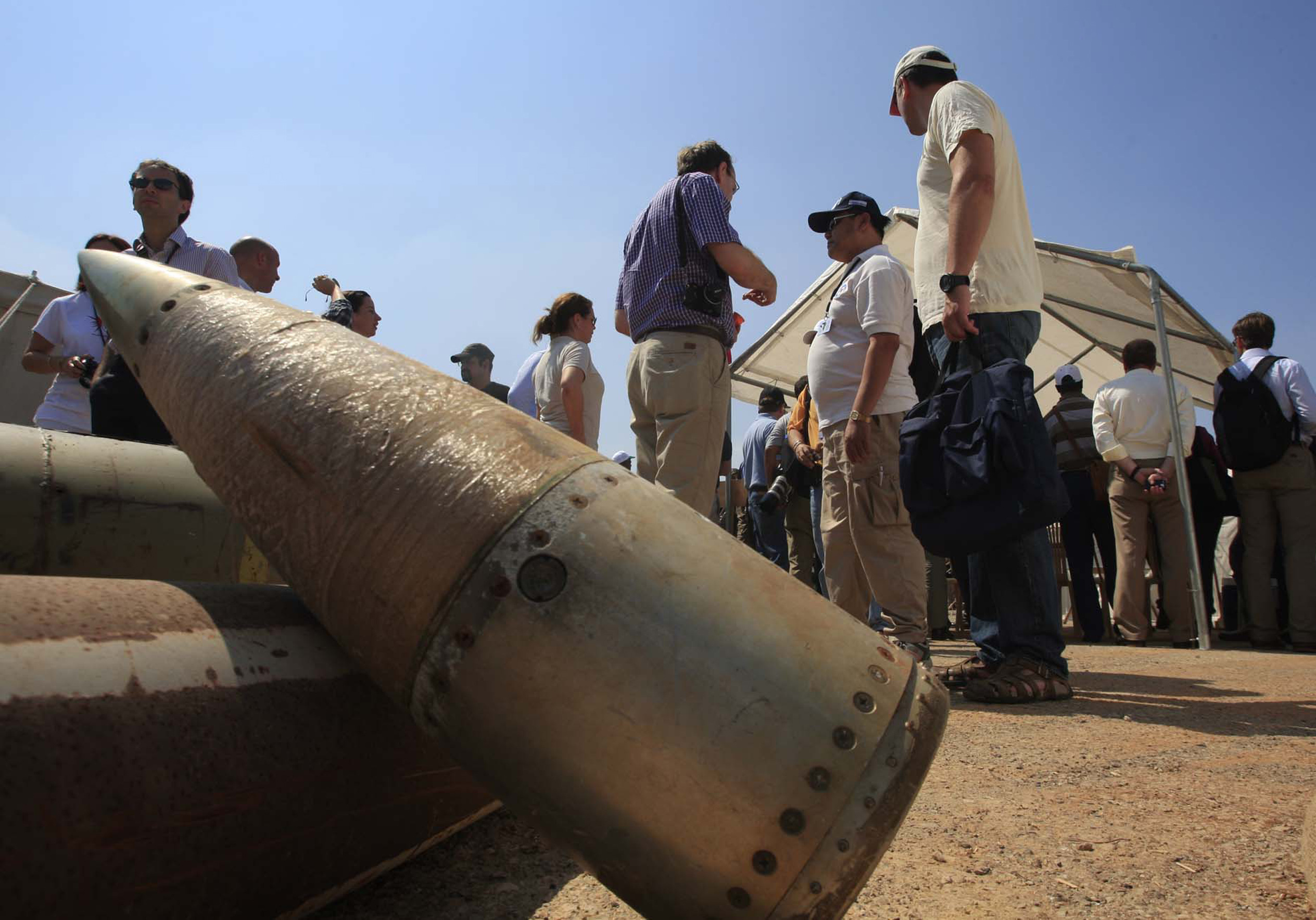FILE - Activists and international delegations stand next to cluster bomb units, during a visit to ...