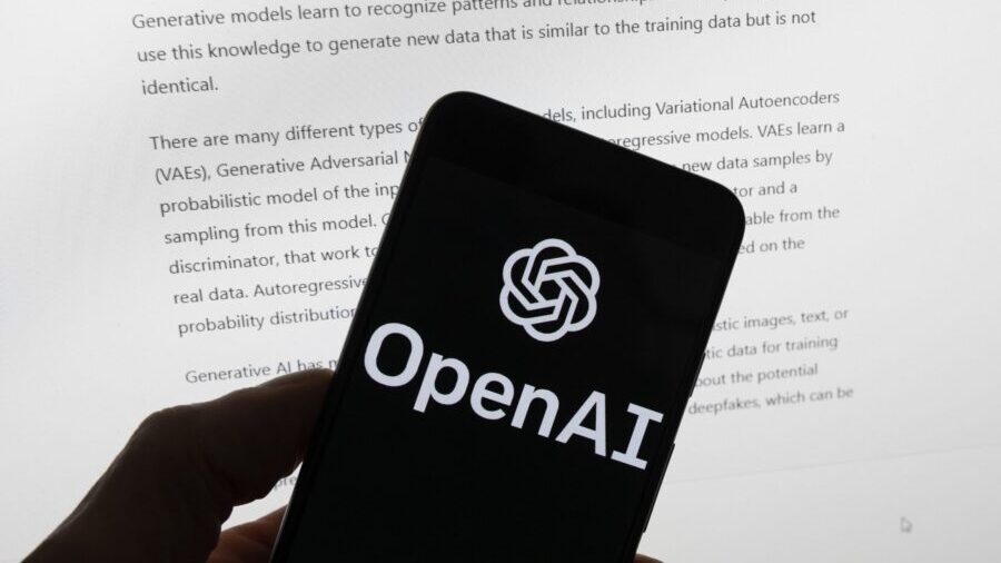 FILE - The OpenAI logo is seen on a mobile phone in front of a computer screen displaying output fr...