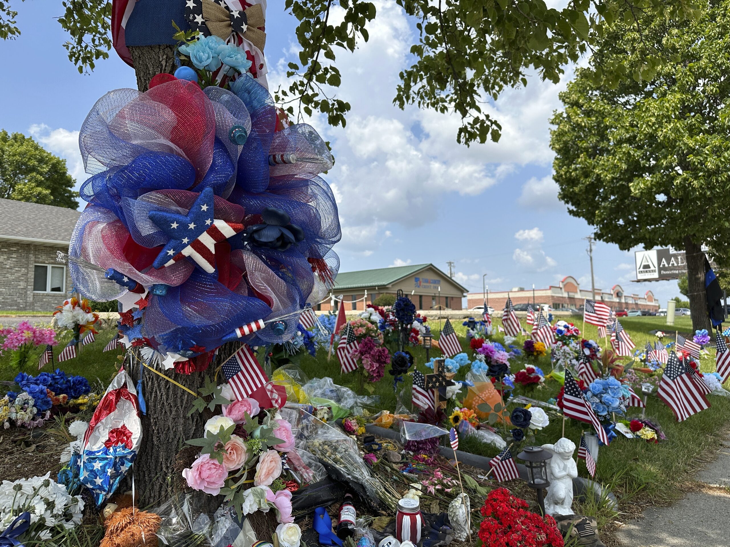Flowers and flags are placed at the memorial for fallen Fargo Police Officer Jake Wallin in Fargo, ...