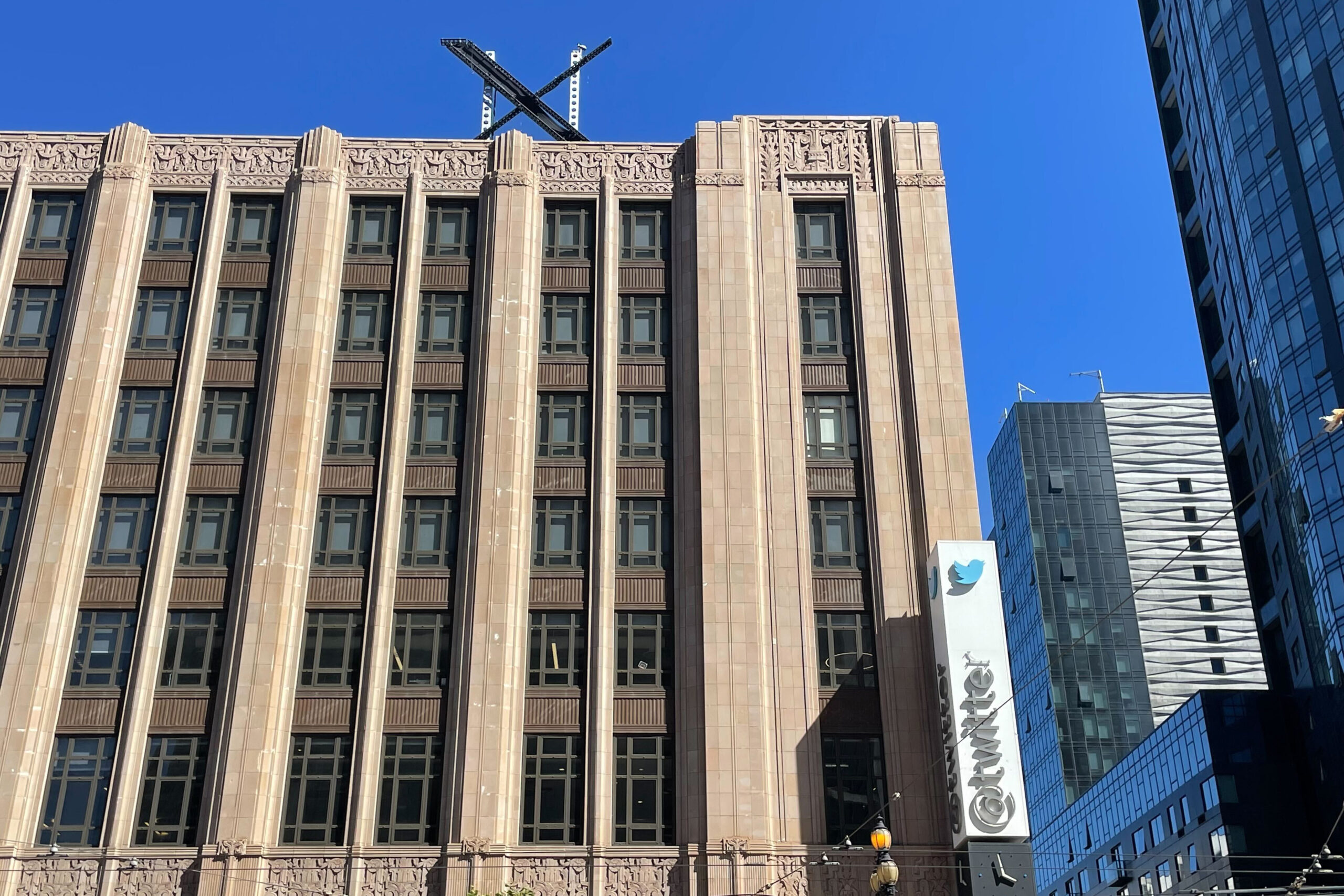 A large, metal "X" sign is seen on top of the downtown building that housed what was once Twitter, ...