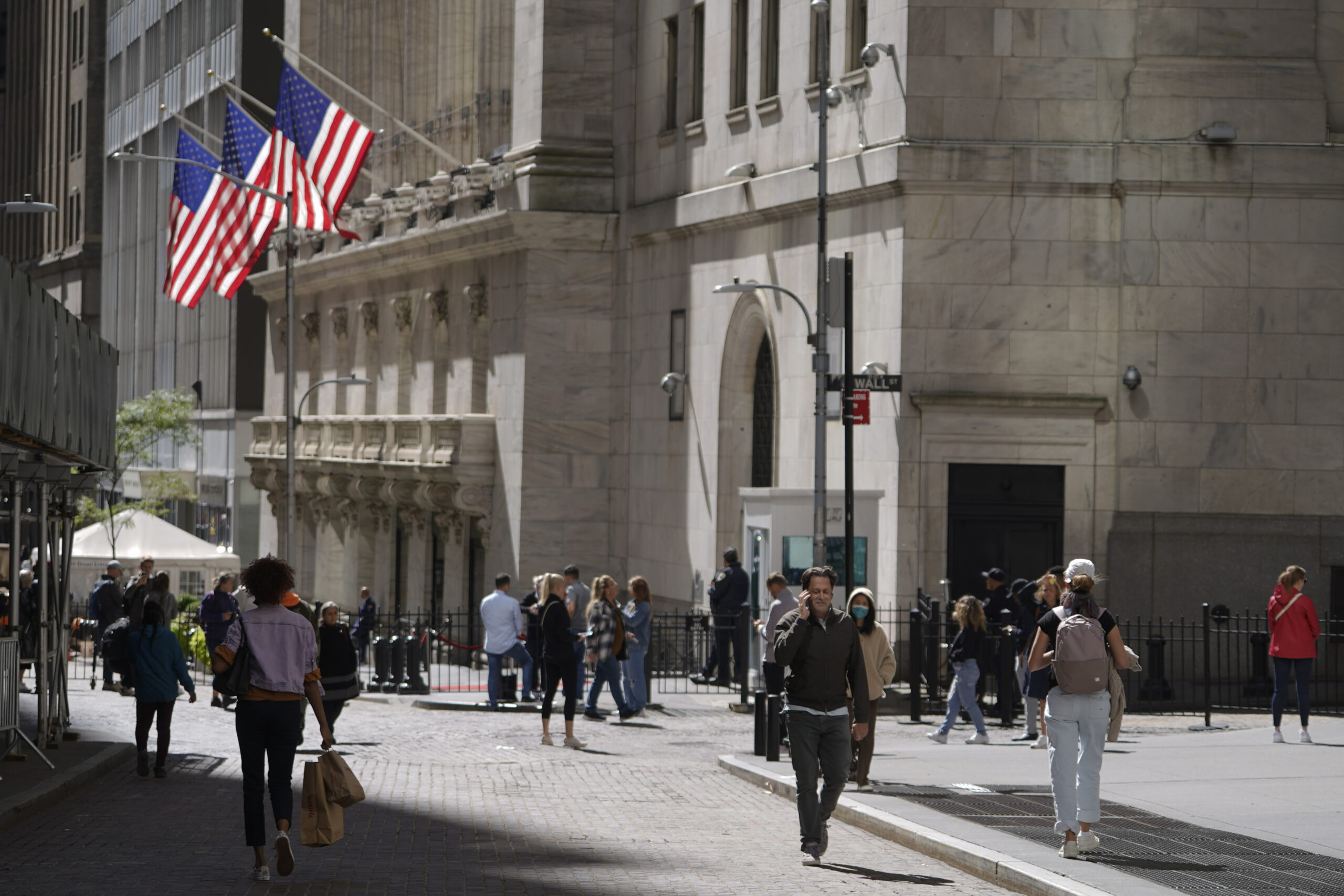 FILE - Visitors to the financial district walk past the New York Stock Exchange, Friday, Sept. 23, ...