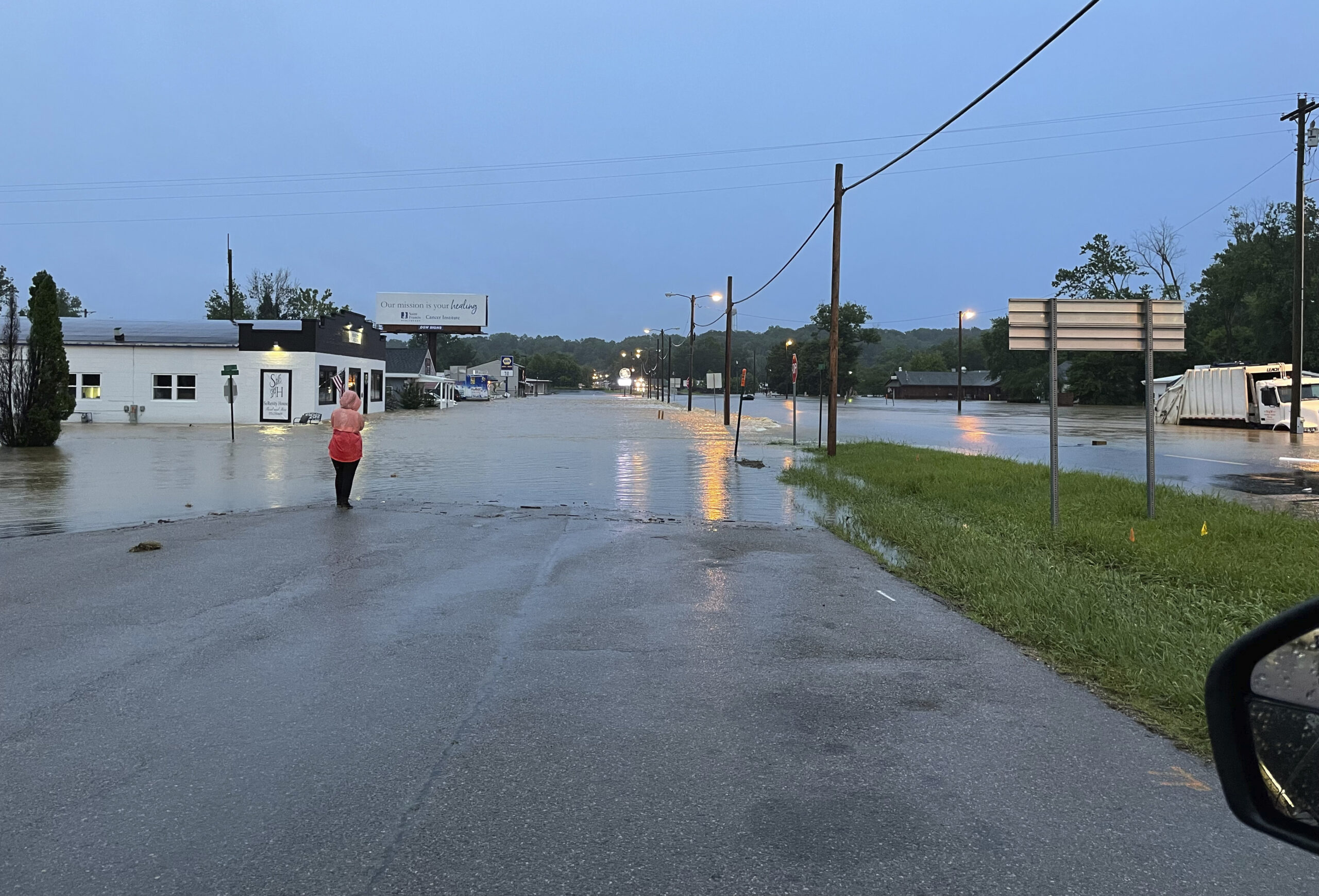 In this photo provided by the Missouri State Highway Patrol, a woman looks over a flooded street in...