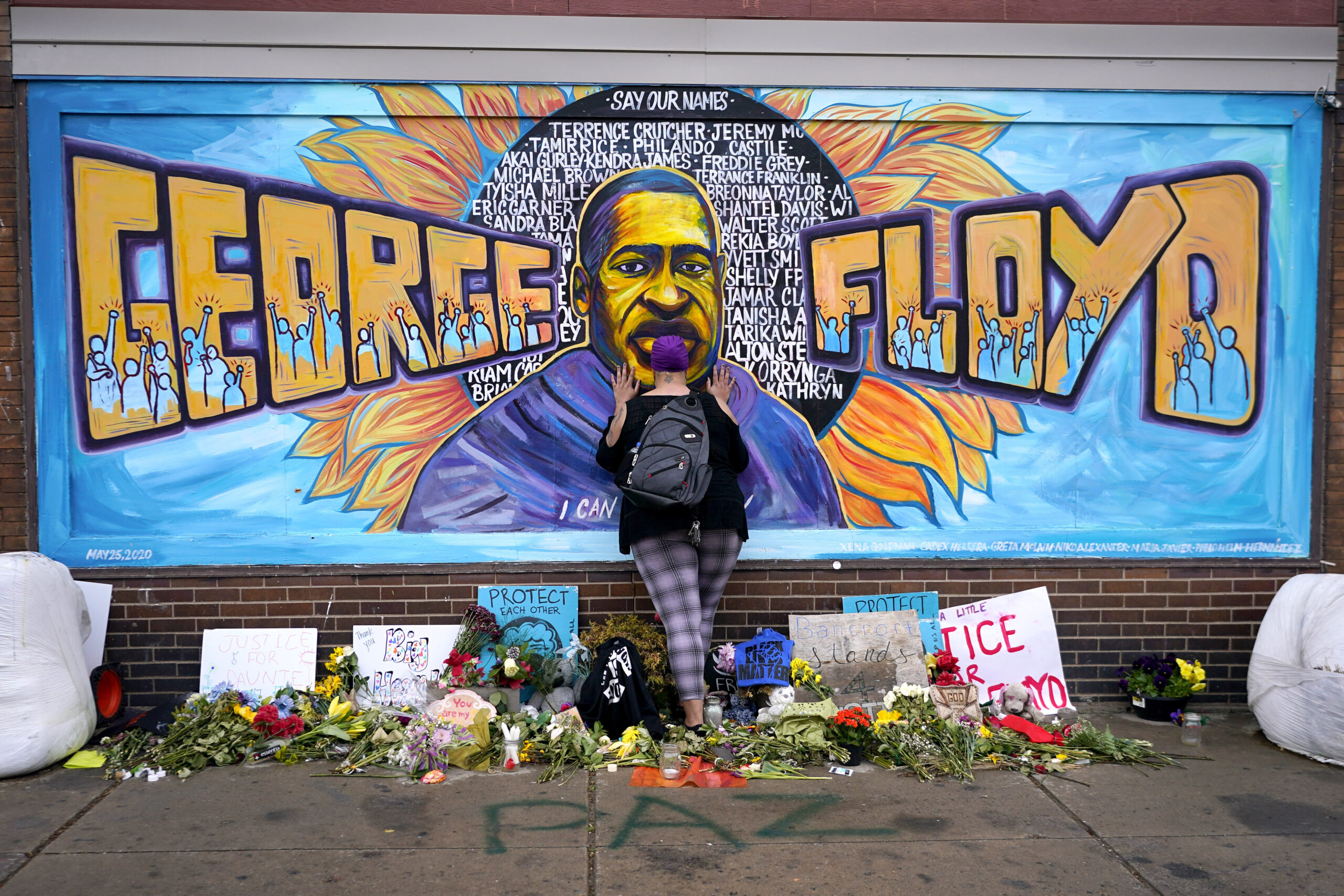 FILE - Damarra Atkins pays respect to George Floyd at a mural at George Floyd Square in Minneapolis...