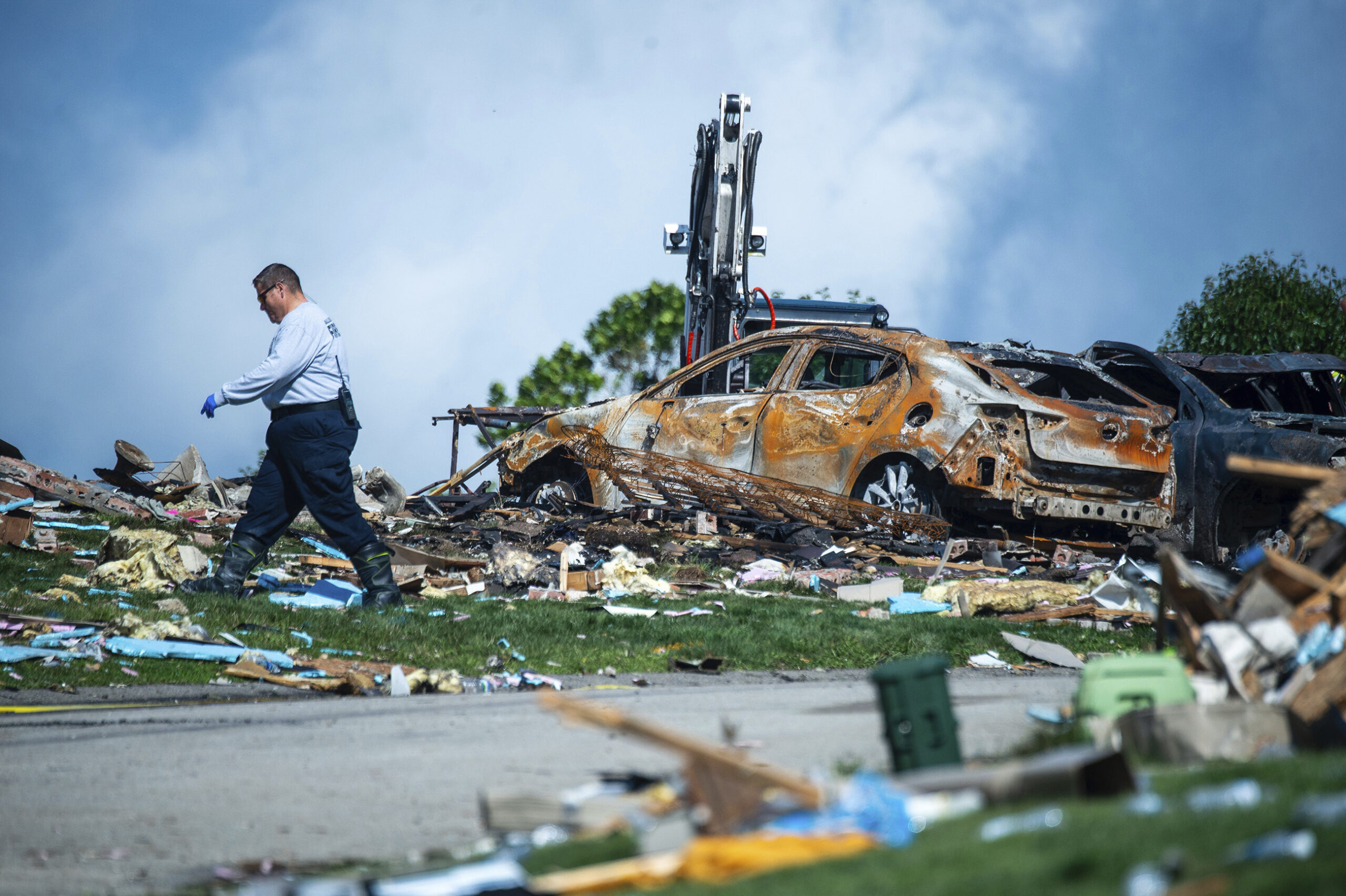 An investigator walks through the debris from a home explosion which occurred the day before in Plu...