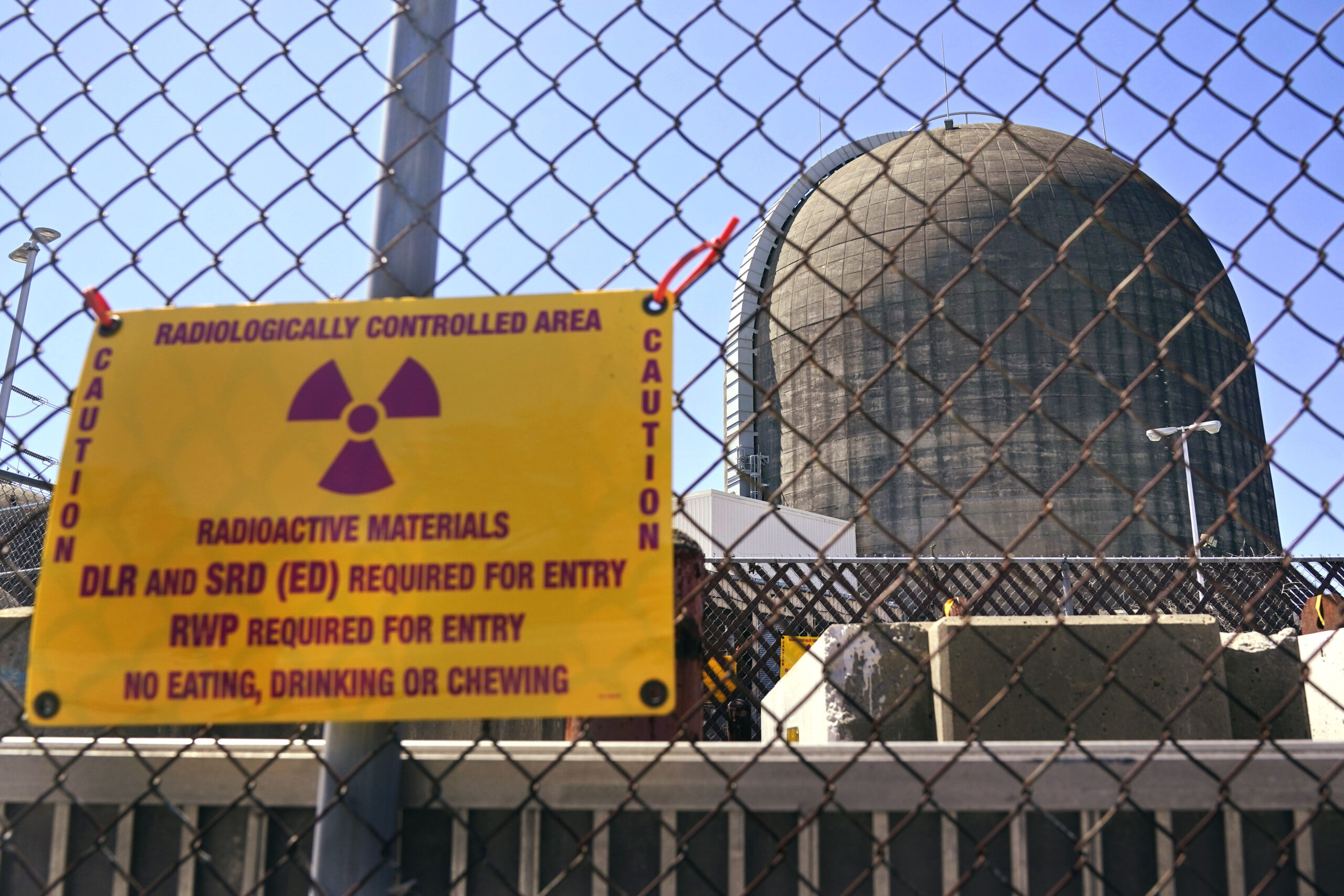 FILE - A sign warning of radioactive materials is seen on a fence around a nuclear reactor containm...