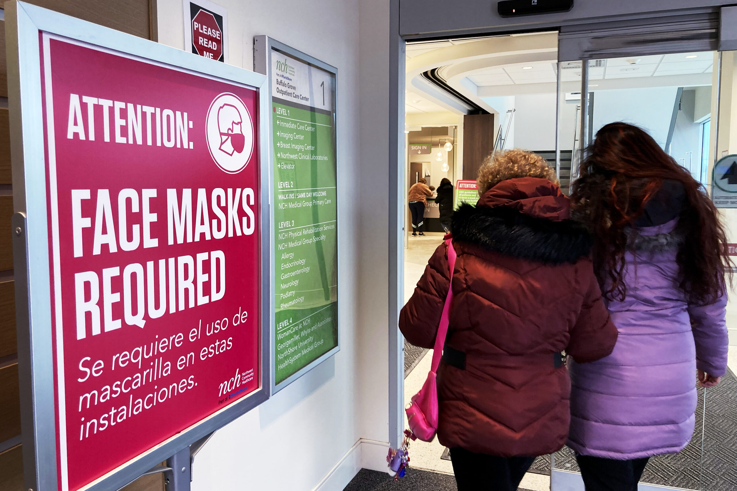 A sign announcing a face mask requirement is displayed at a hospital in Buffalo Grove, Ill., Friday...