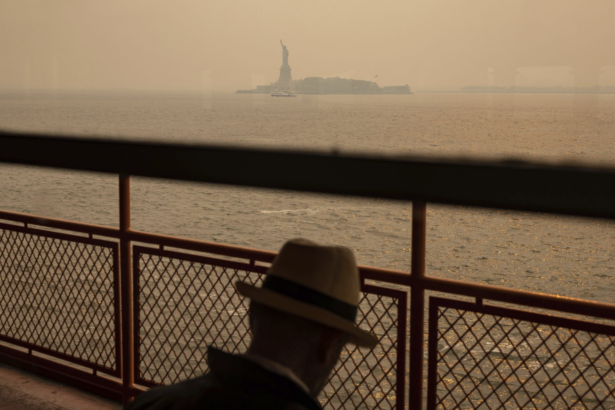 FILE - The Statue of Liberty, covered in a haze-filled sky, is photographed from the Staten Island ...