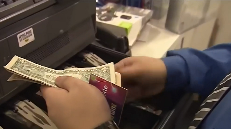 Image: A cashier handles money during a recent transaction....
