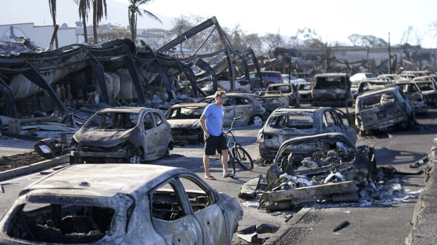 FILE - A man walks through wildfire wreckage in Lahaina, Hawaii, Aug. 11, 2023. Federal authorities...