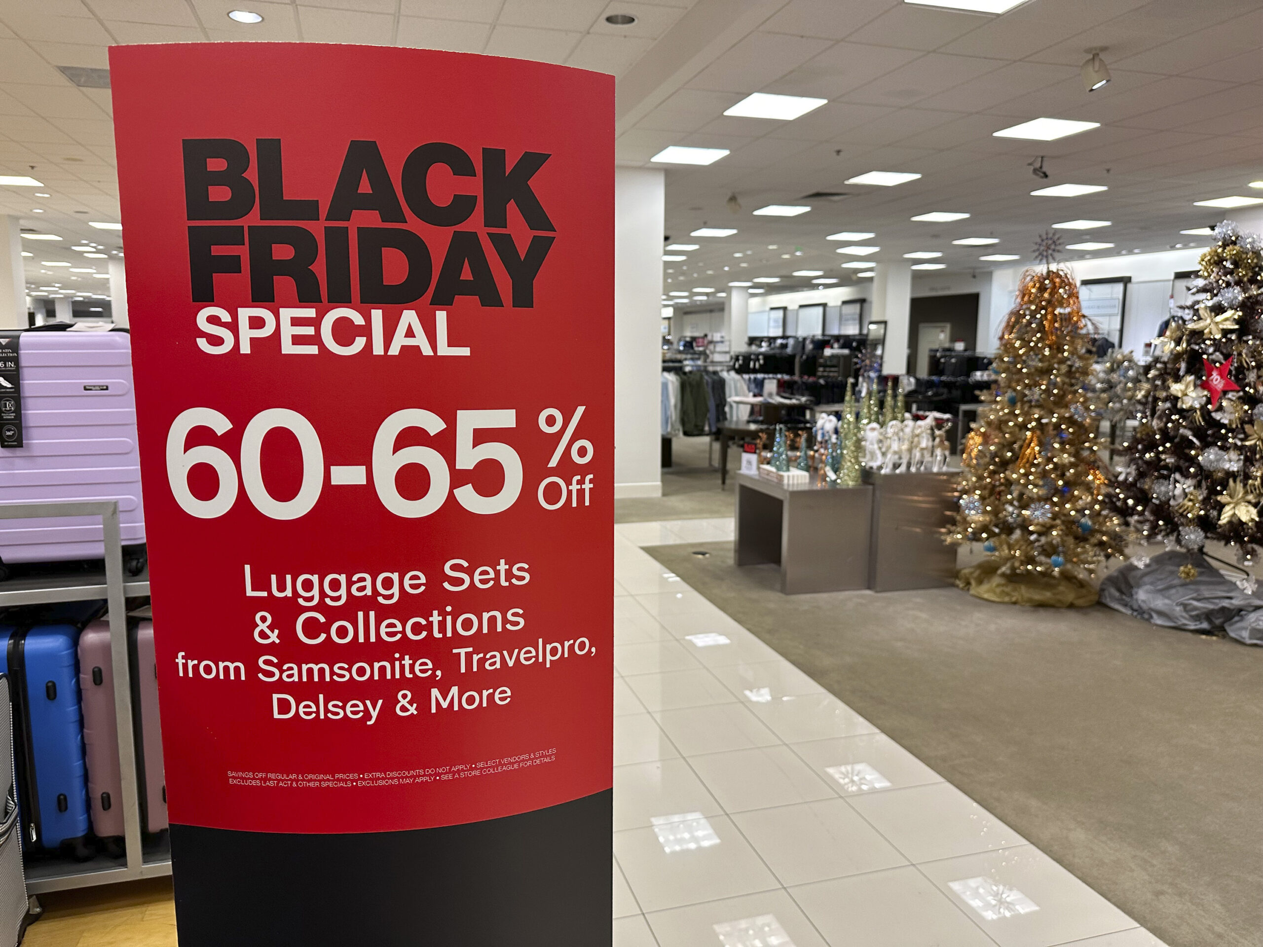 A sign announces Black Friday specials on luggage sets inside a Macy's department store on Monday, ...