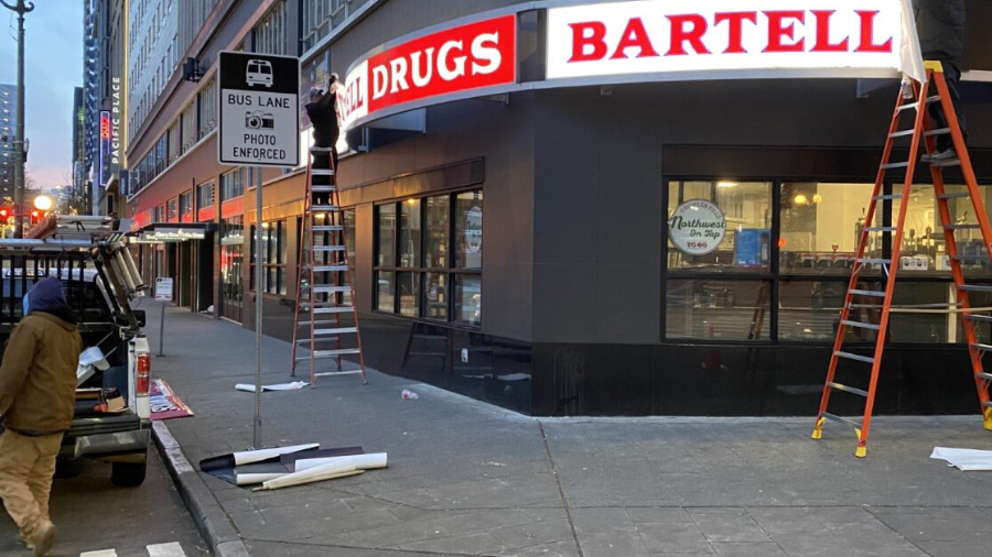 Workers take down sign of the last Bartell Drugs in downtown Seattle...