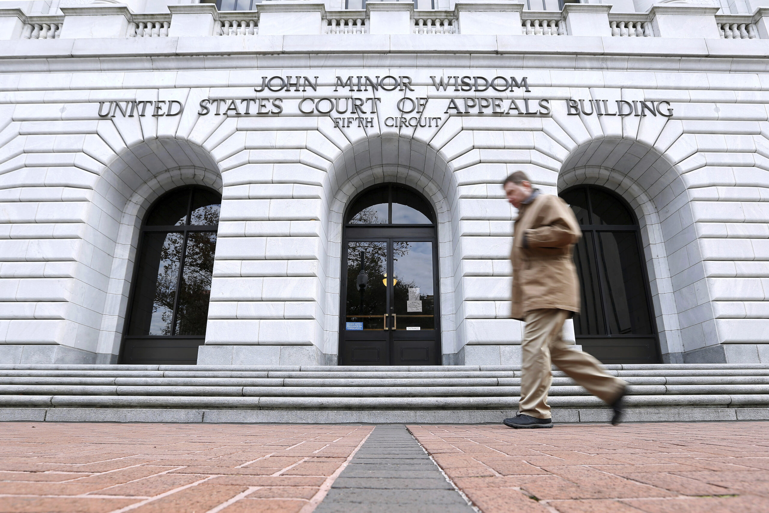 FILE - A man walks in front of the 5th U.S. Circuit Court of Appeals, Jan. 7, 2015, in New Orleans....