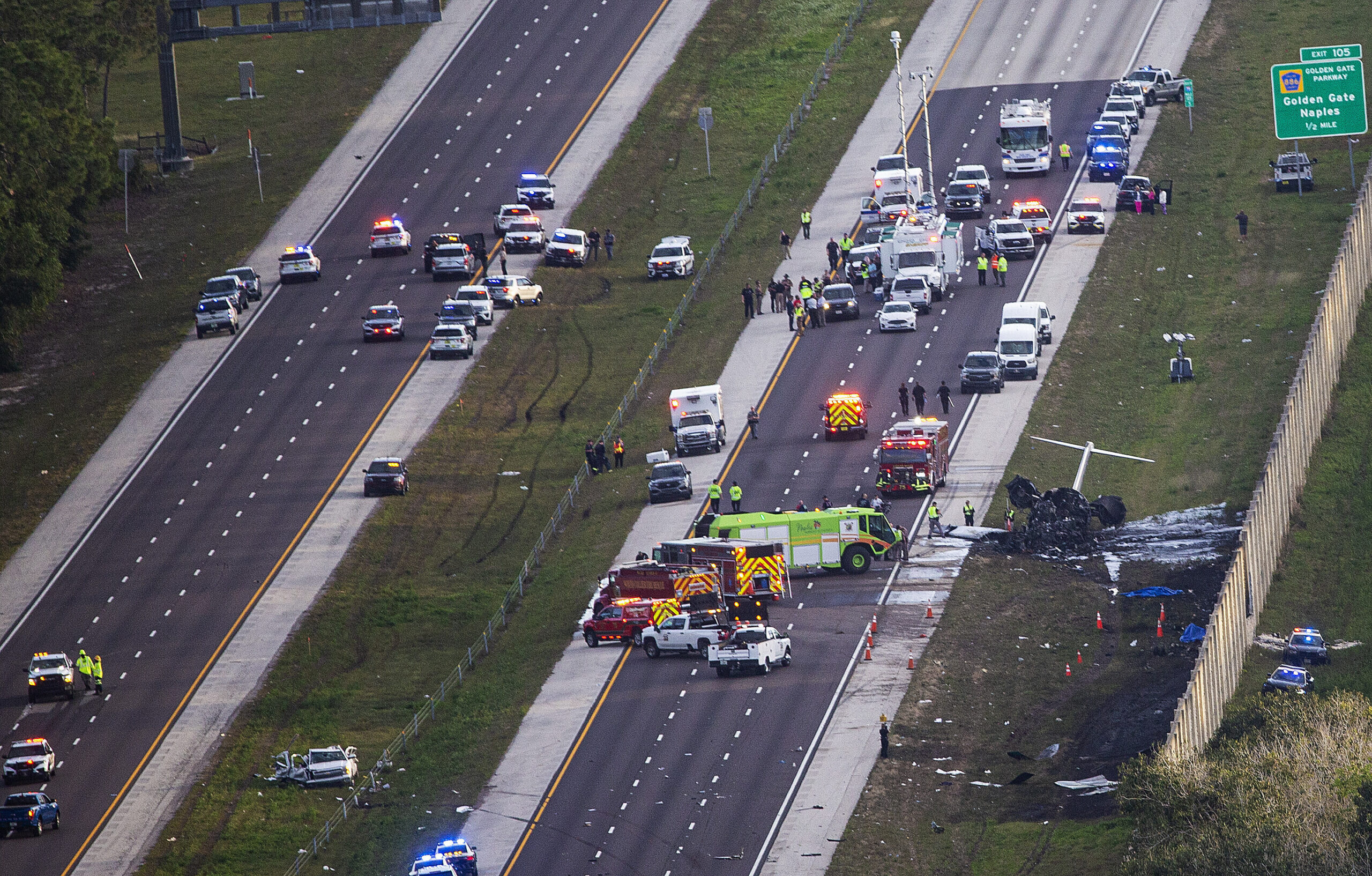 Emergency officials work the scene of a small plane crash on Interstate 75 in Naples, Fla., near Ex...