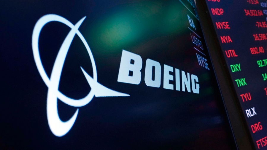 The logo for Boeing appears on a screen above a trading post on the floor of the New York Stock Exc...