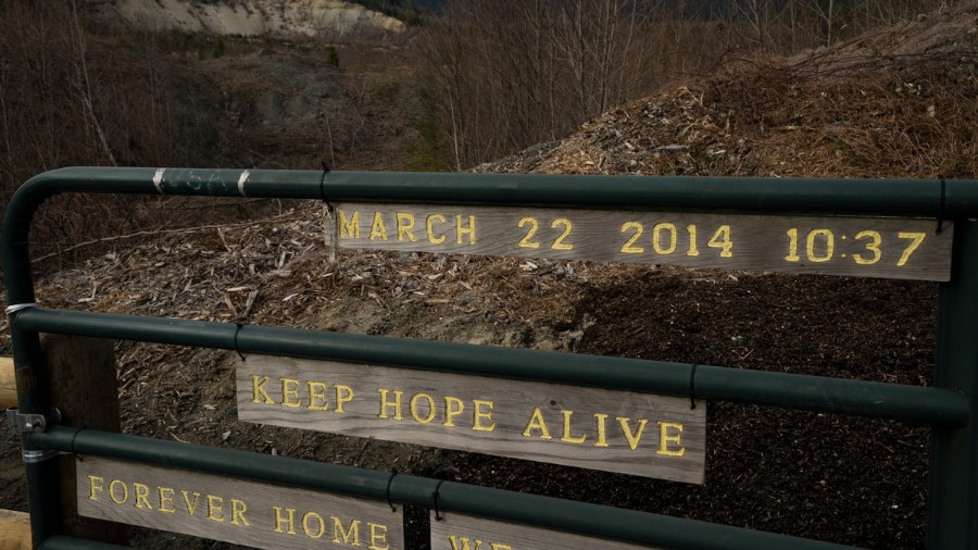 Image: The Oso landslide scar is seen near a sign at the memorial site on Saturday, Feb. 17, 2024, ...