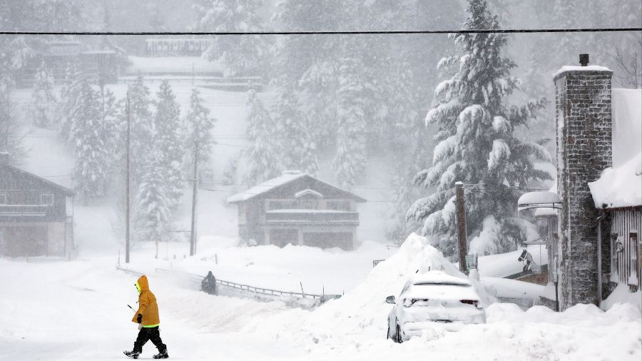 A worker carries a snow shovel in Truckee, CA. as blizzard consitions persist, (Photo: Mario Tama/G...