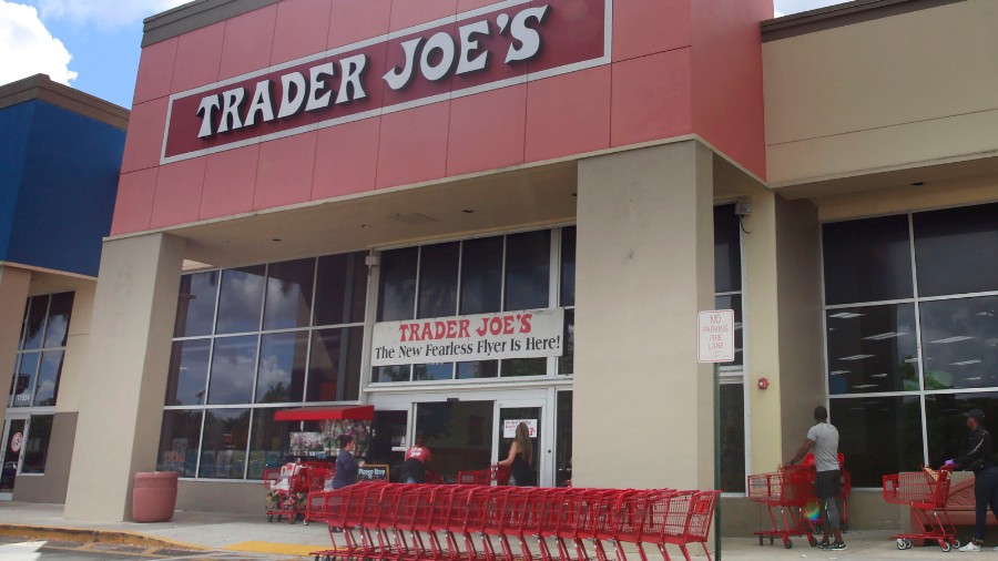 Image: People stand in line waiting to enter Trader Joe's to buy groceries in Pembroke Pines, Flori...