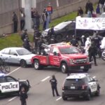 Image: A tow truck removes one of the cars blocking the expressway leading to Seattle-Tacoma International Airport on Monday, April 15, 2024. A pro-Palestinian protest closed the road to the airport.